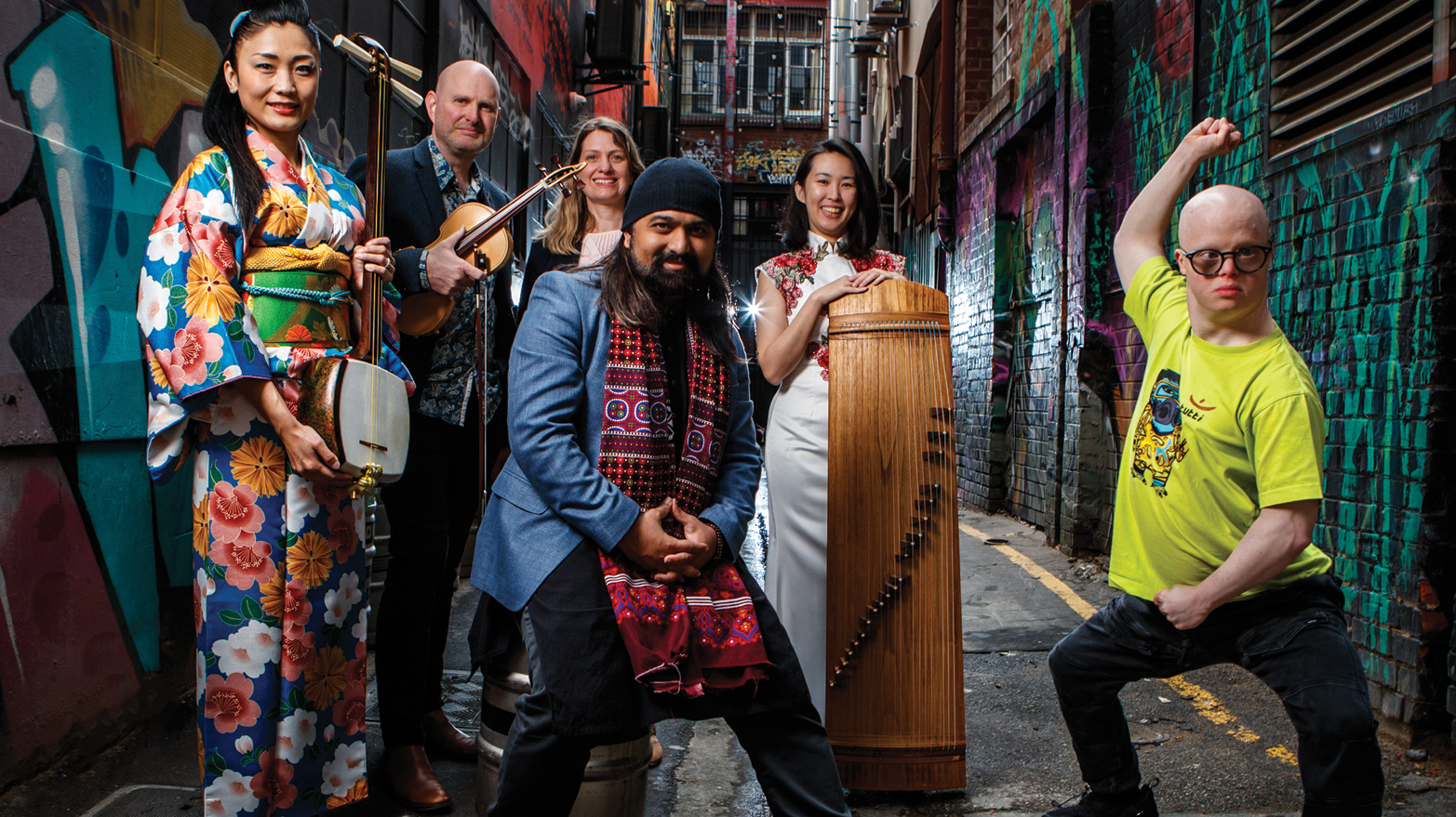 Musicians of the Adelaide Symphony Orchestra posing with their instruments in an alley.