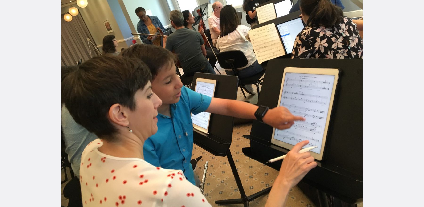Angel Reverol, a flute student in the Nashville Symphony’s Accelerando program for young musicians, shows his instructor, Leslie Fagan, assistant principal flute with the Nashville Symphony, how to use a tablet with a digital score during a rehearsal.